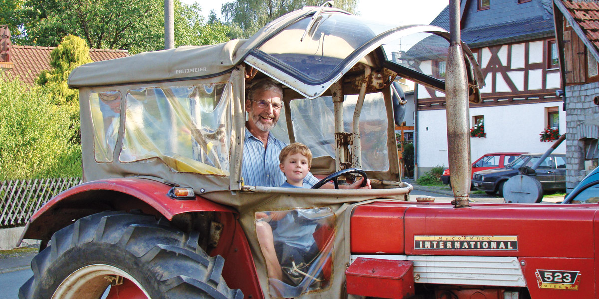 Hartmud Schröder mit seinem ersten Enkelkind auf einem Traktor